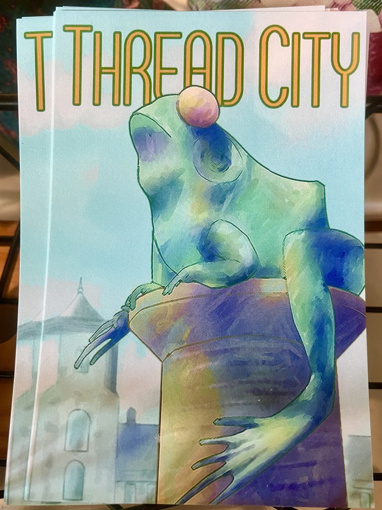 A stack of post cards displaying artwork depicting  Willimantic's "Frog Bridge"