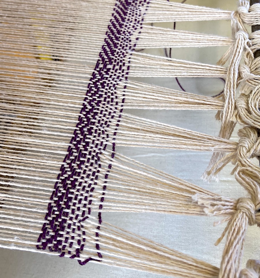 Close up of warp and weft on a loom