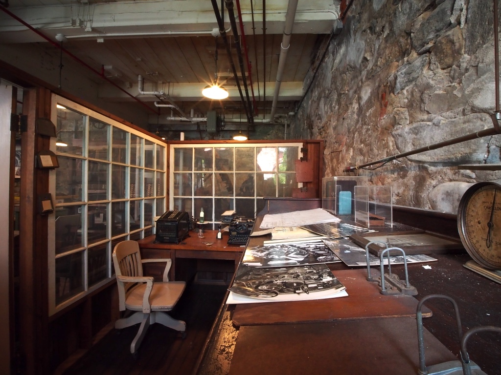 A photograph showing an example of the supervisor's area in the thread mills. This exhibit is also used to showcase engineering-related artifacts.